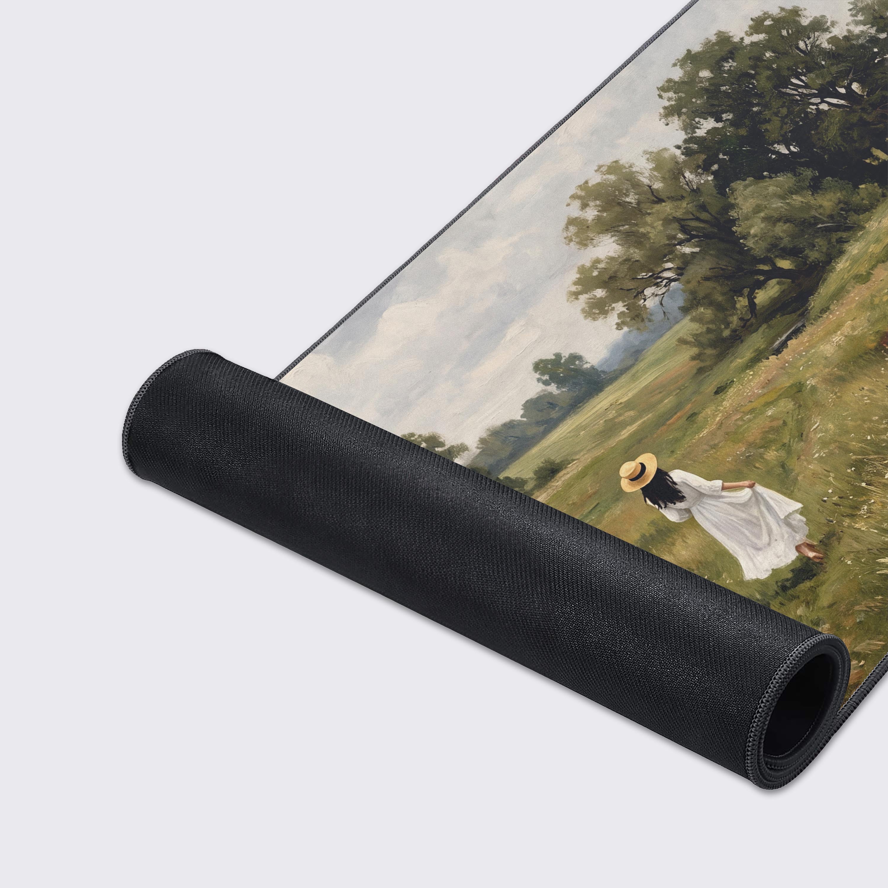 Top-down view of the countryside landscape desk mat featuring towering trees and a cloudy sky.