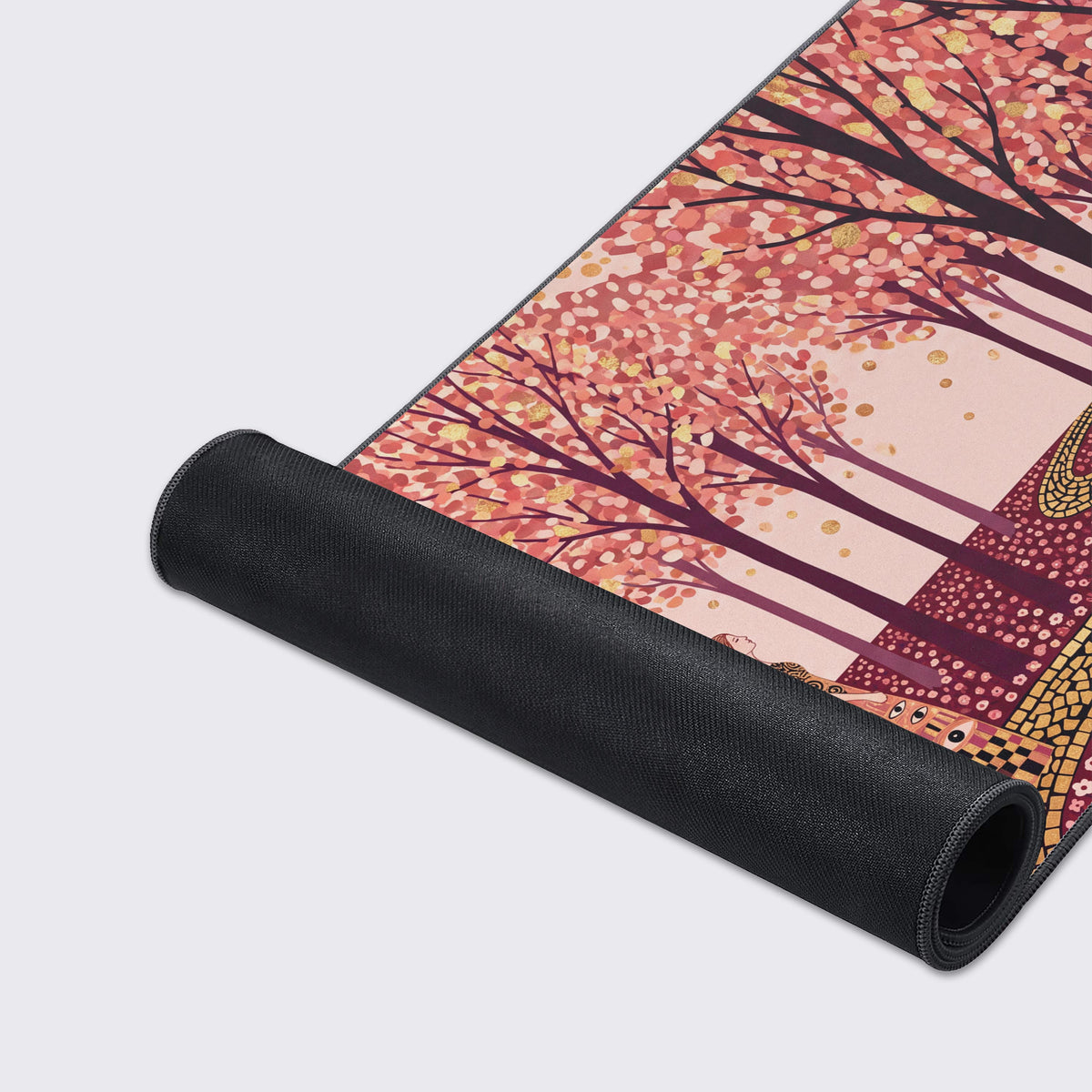 Desk mat partly rolled up showing its black rubber underside beside pink blossom trees and gold mosaic path art