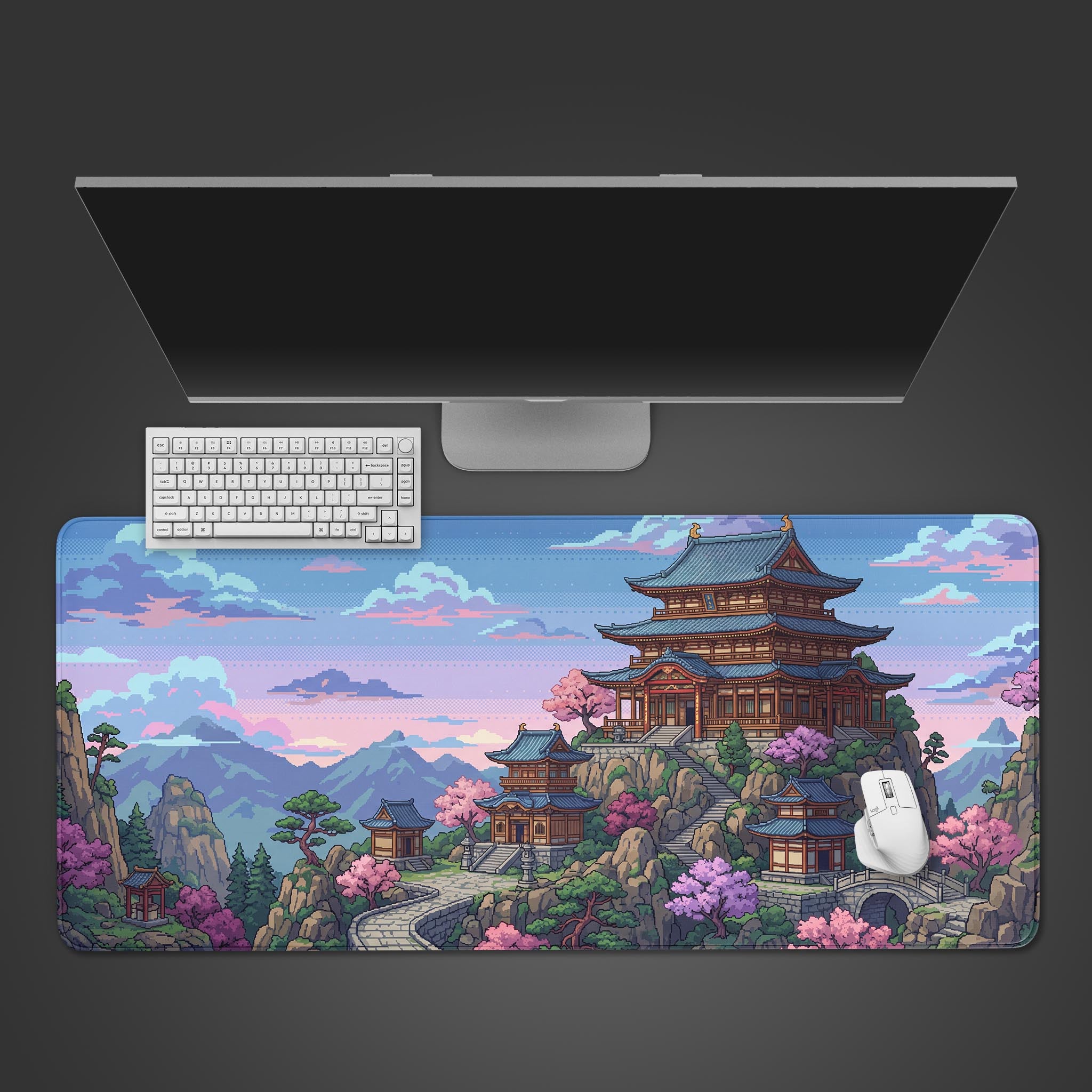 Top-down view of the Pixel Pagoda Peak Gaming Desk Mat, showing its Japanese mountain temple design beneath a sleek monitor, white keyboard, and mouse. - Epic Design Pads & Mousepads