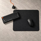 Pro Series 490 black mouse pad from above on a stone desk, with a black keyboard and gaming mouse; black stitched edge