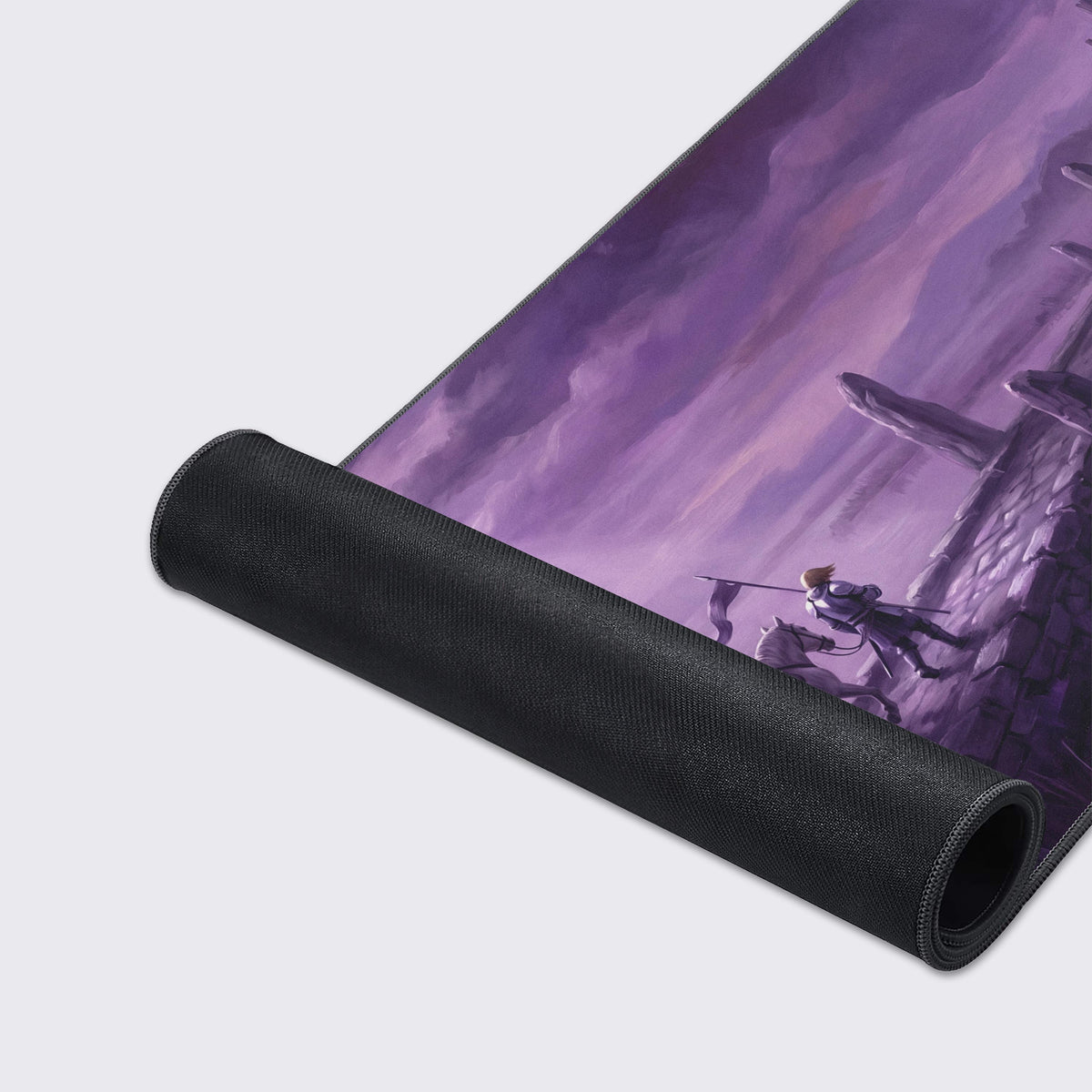 Desk mat partly rolled up showing its black rubber underside beside the purple art of the knight and white horse