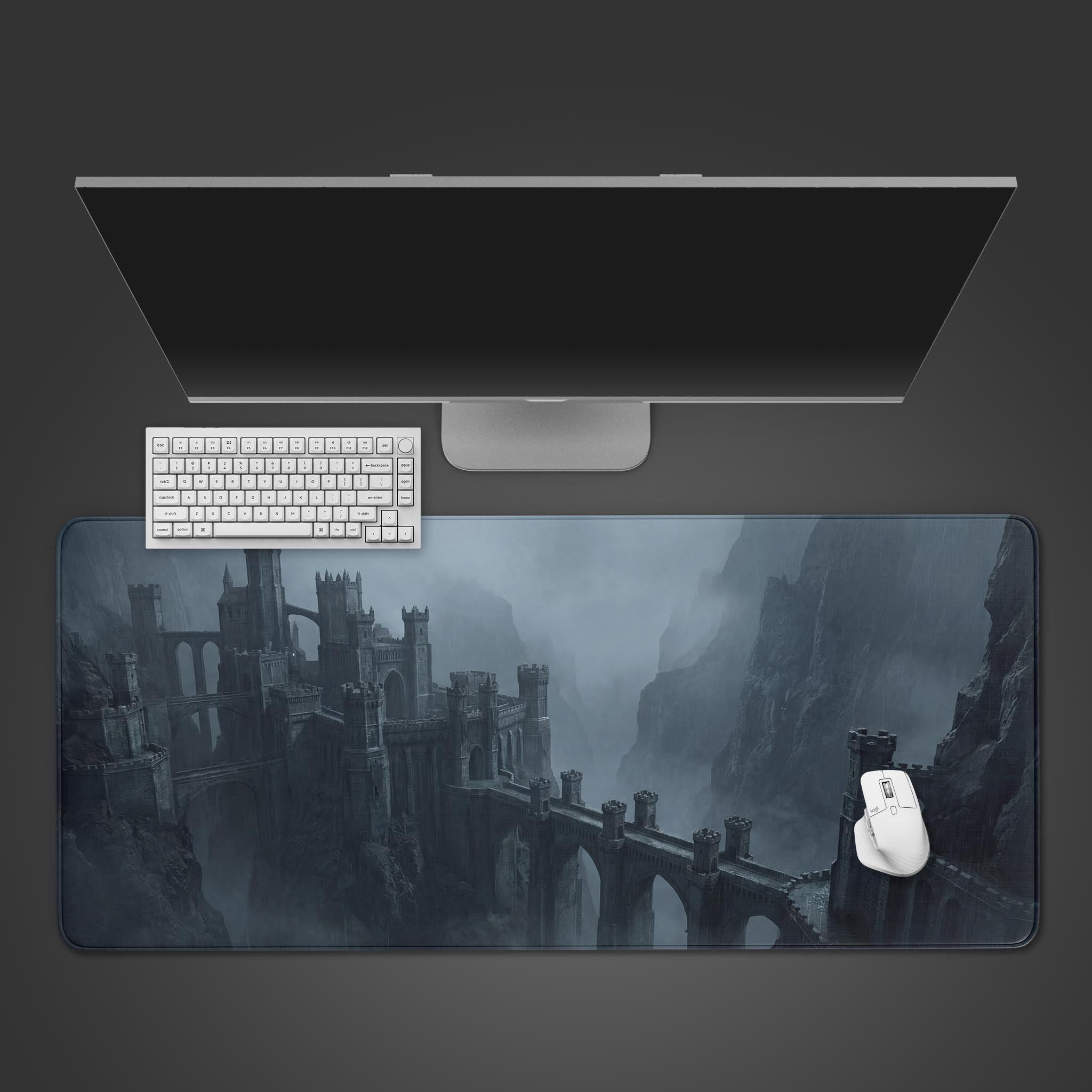 Top-down view of the Shadow Fortress Gaming Desk Mat featuring a gothic castle design, shown with a white mechanical keyboard and mouse on a dark grey background. - Epic Design Pads & Mousepads