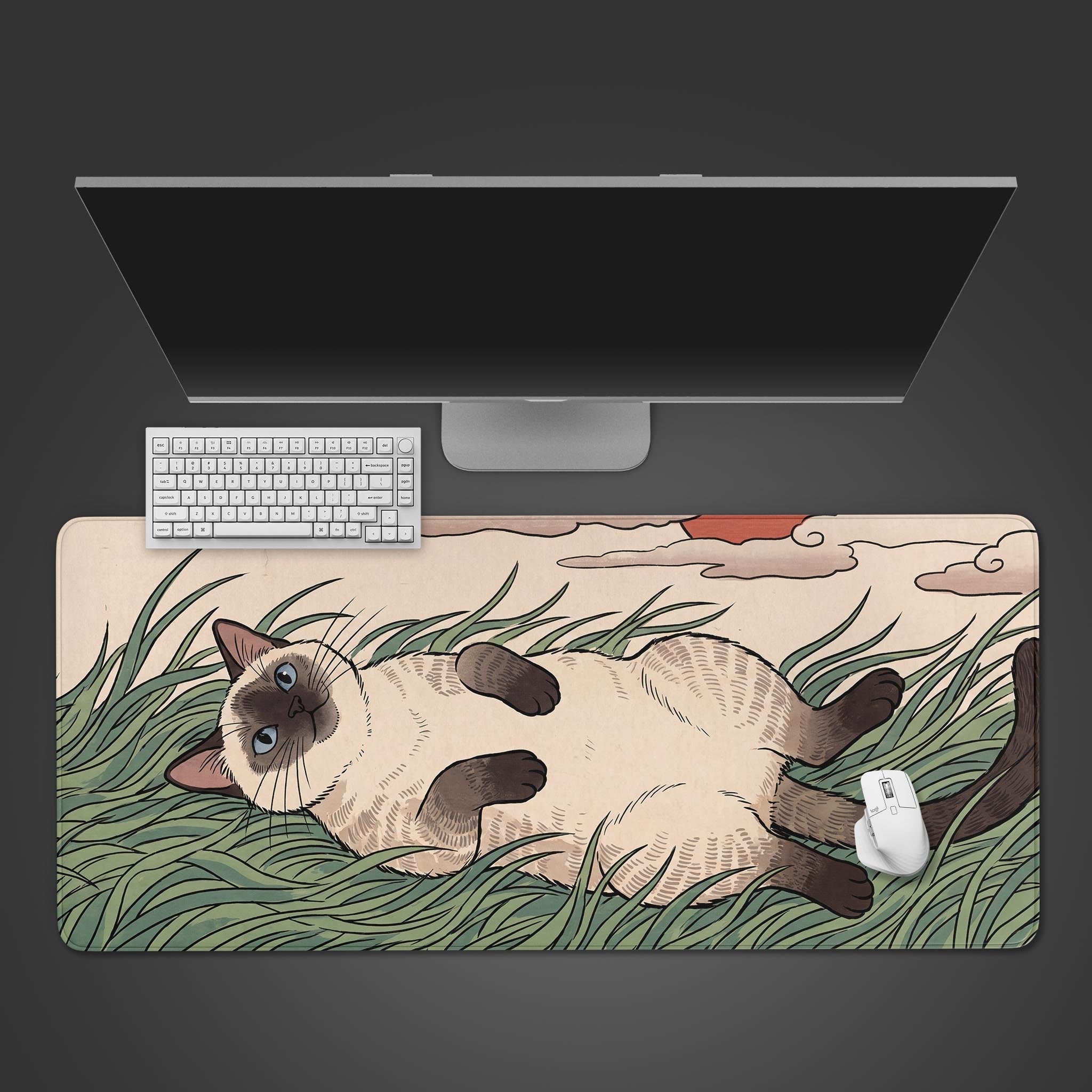 A desk mat featuring an illustration of a Siamese cat lying on its back in tall green grass under a beige sky with a red sun.