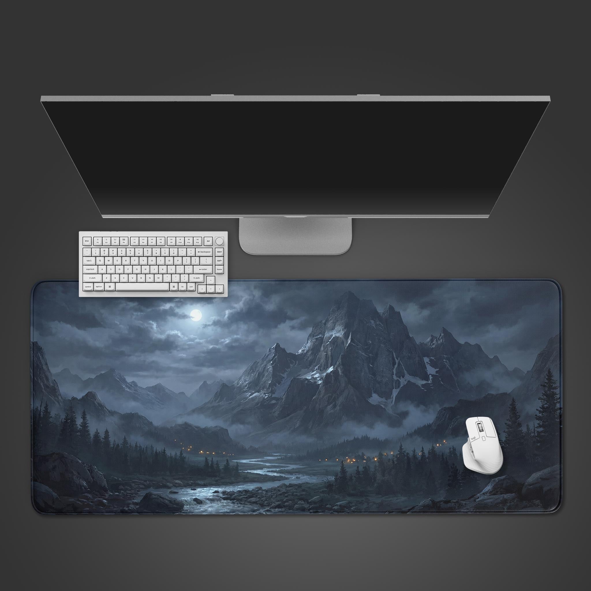 Top-down view of the Silent Alpine gaming desk mat featuring a moody mountain landscape, shown with a white keyboard and mouse on a dark surface. - Epic Design Pads & Mousepads