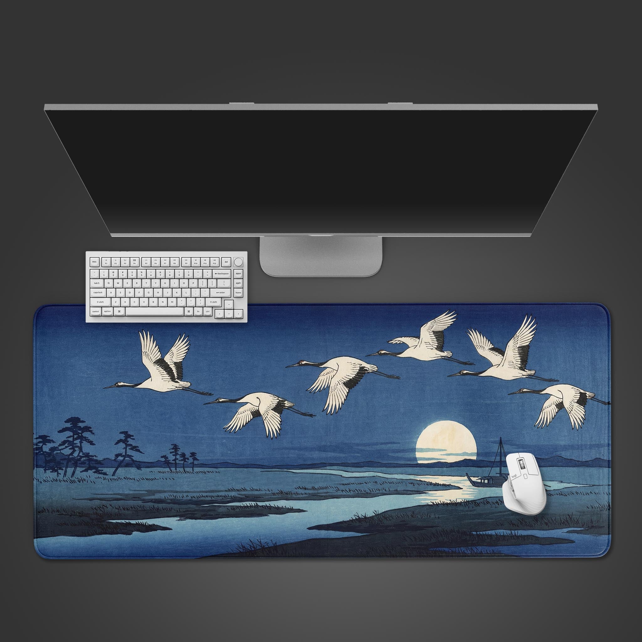 Top-down view of the Silent Migration gaming desk mat featuring Japanese cranes. A white keyboard and mouse are placed on the mat, below a large monitor, showcasing a clean workspace setup. - Epic Design Pads & Mousepads