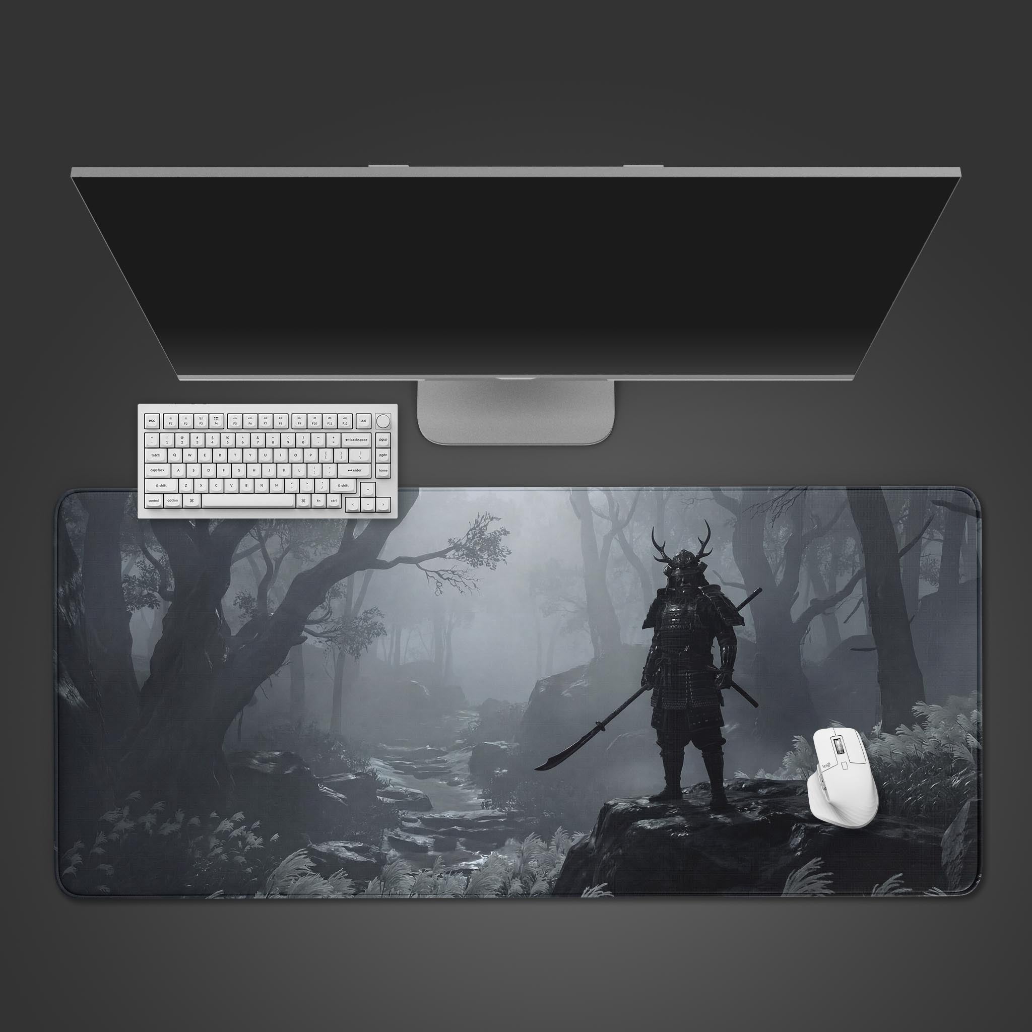 The Silent Ronin Gaming Desk Mat shown in a top-down view with a white keyboard, mouse, and monitor, featuring a monochrome samurai in a misty forest. - Epic Design Pads & Mousepads