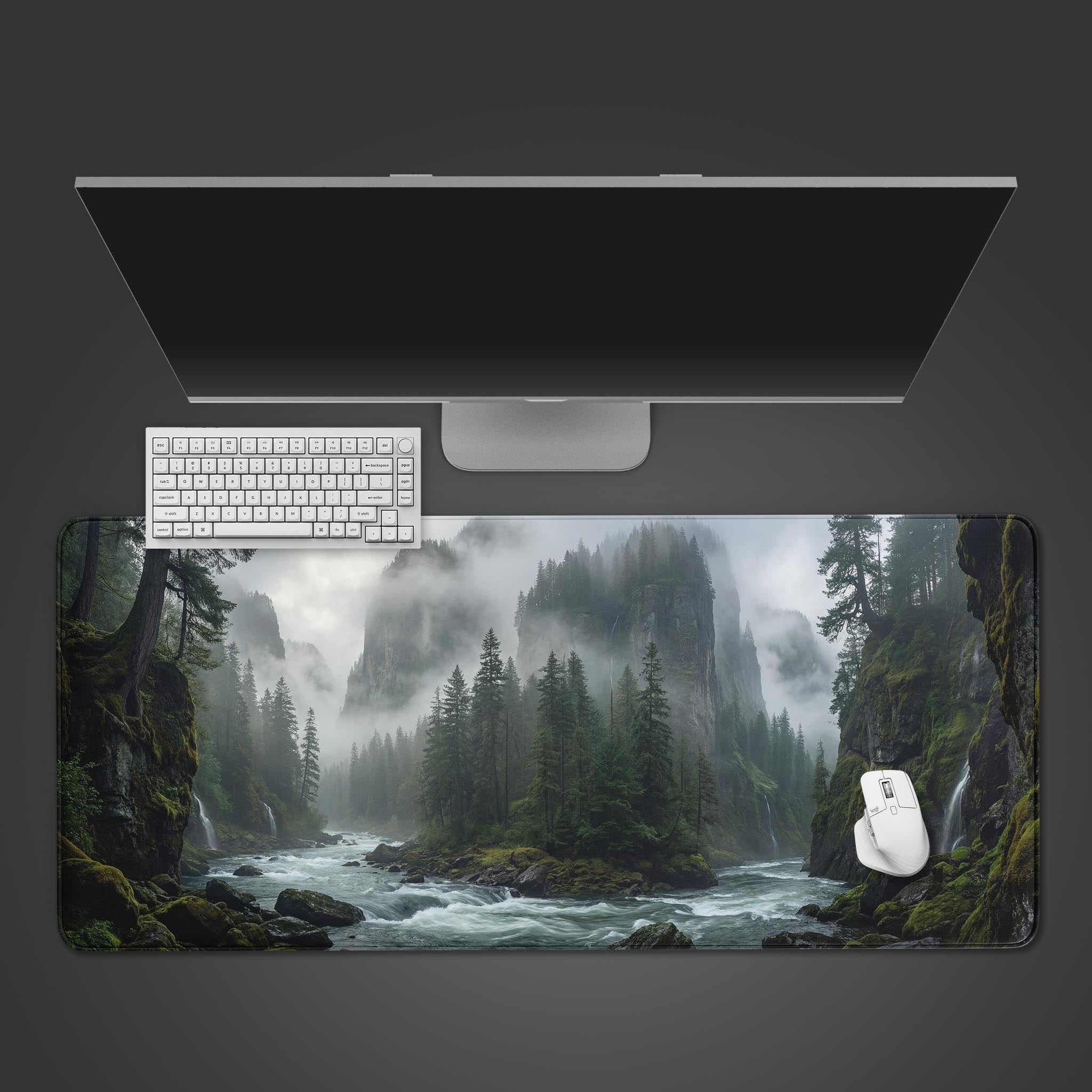 Top-down view of the Silent Valley gaming desk mat, showcasing its misty river gorge design with a white keyboard and mouse placed on top, beneath a sleek monitor. - Epic Design Pads & Mousepads