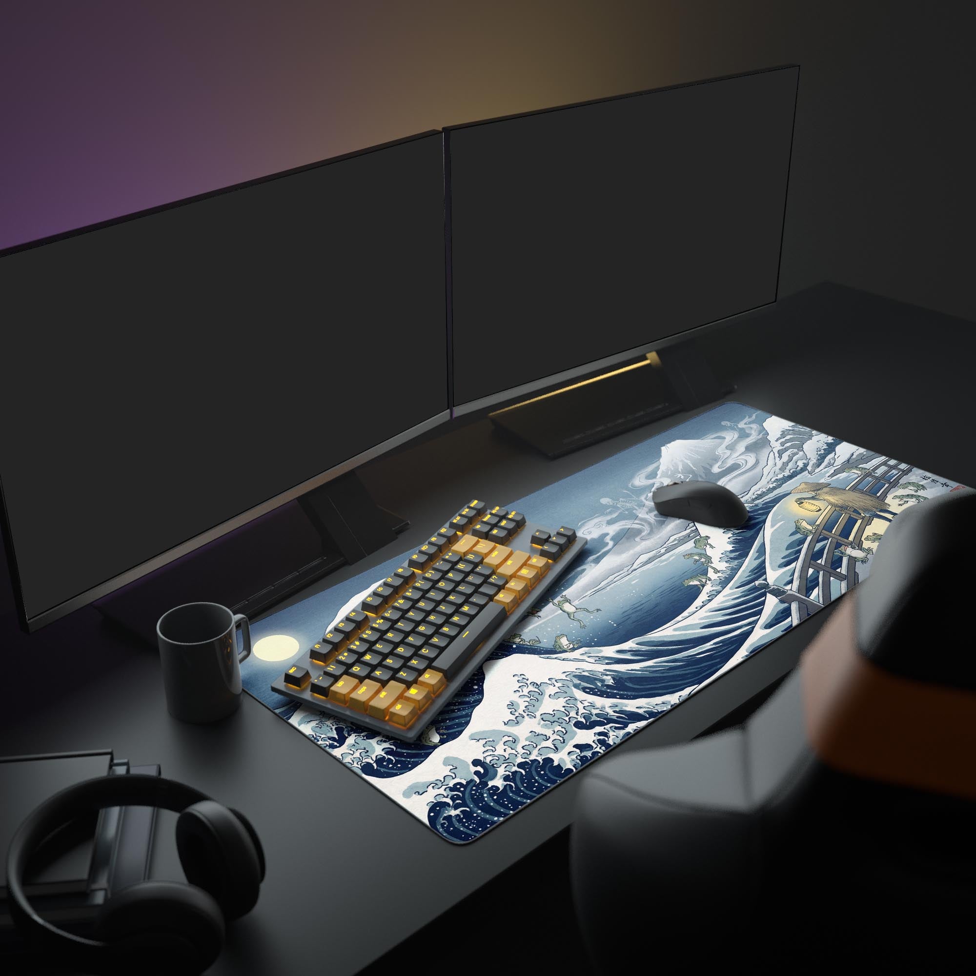 A full PC gaming setup showcasing the Spectral Great Wave mouse pad, which features Ukiyo-e style frogs and ghosts, alongside monitors and an illuminated keyboard. - Epic Design Pads & Mousepads