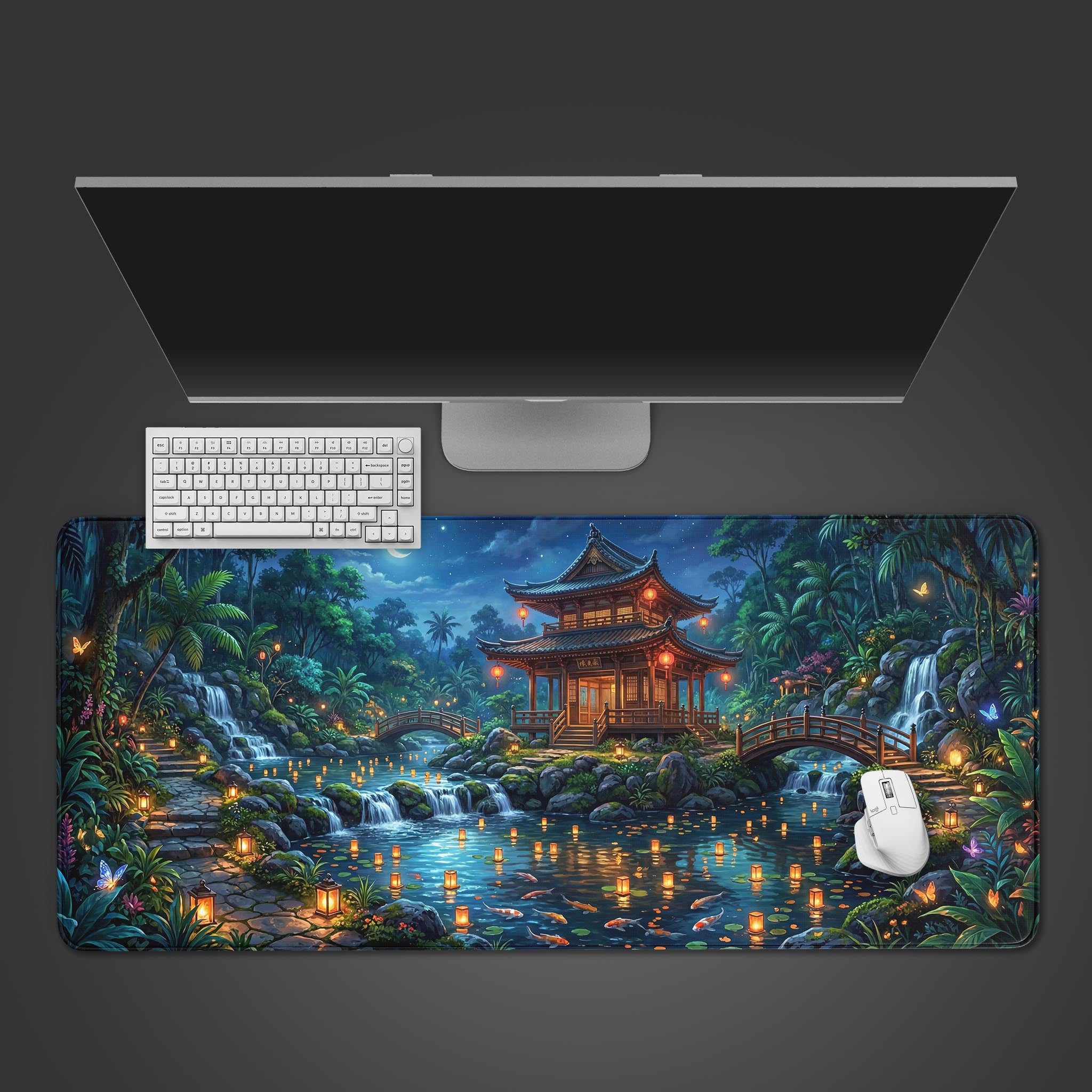 Top-down view of the Spirit Garden gaming desk mat, featuring a Japanese pavilion at night. A white keyboard and mouse are placed on the mat below a sleek monitor. - Epic Design Pads & Mousepads