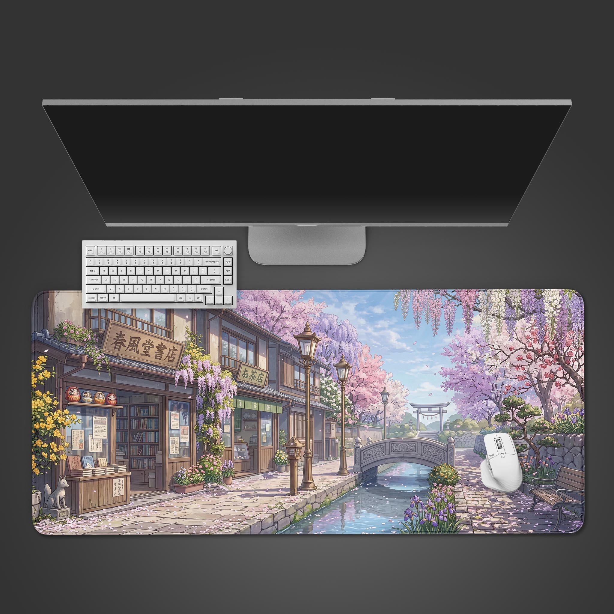 A top-down view of the Springtime Stroll gaming desk mat, showing the anime Japanese town design beneath a white keyboard, mouse, and a large monitor. - Epic Design Pads & Mousepads