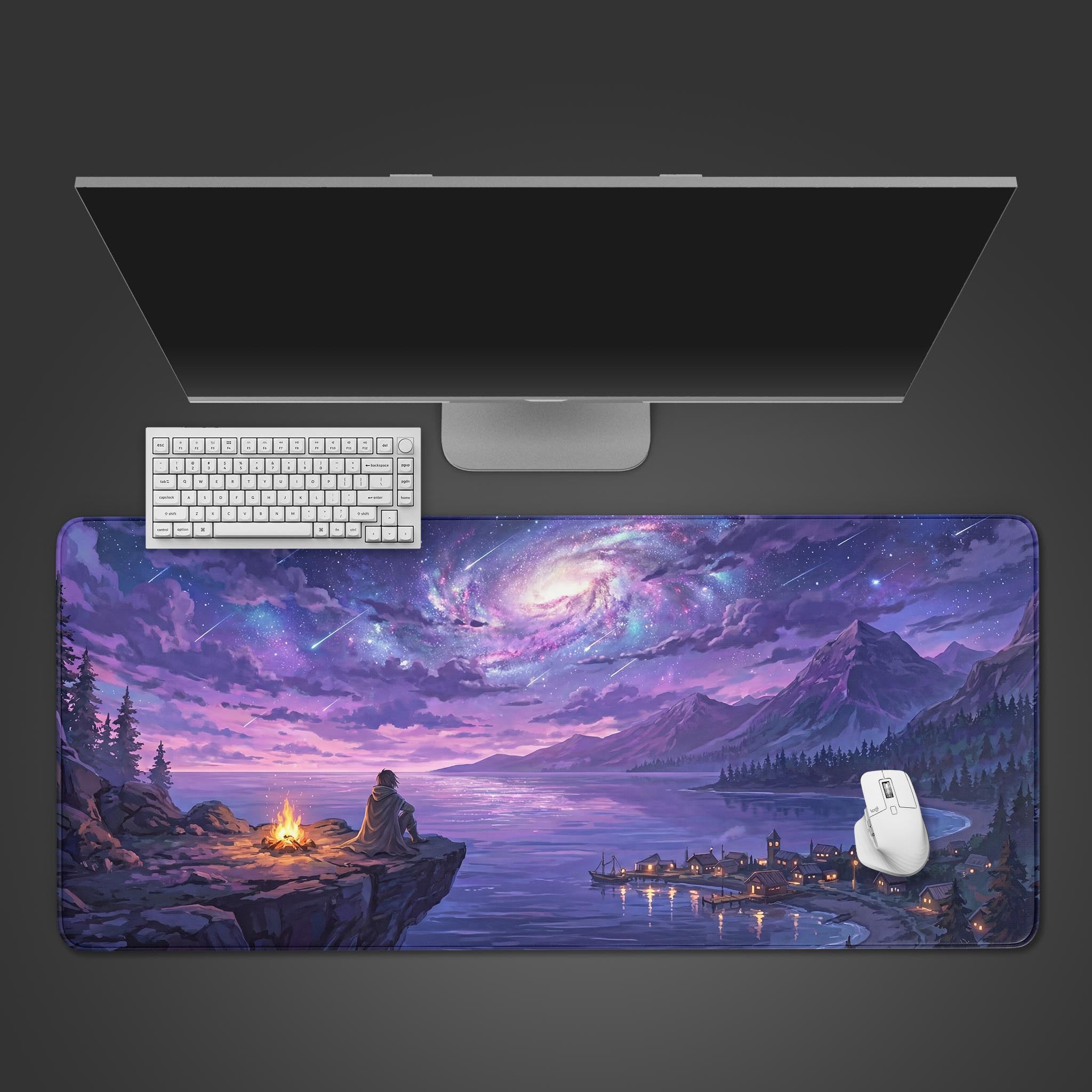 A top-down view of the Starlit Vigil gaming desk mat, showing its vibrant cosmic landscape design beneath a sleek white keyboard, mouse, and a large monitor. - Epic Design Pads & Mousepads