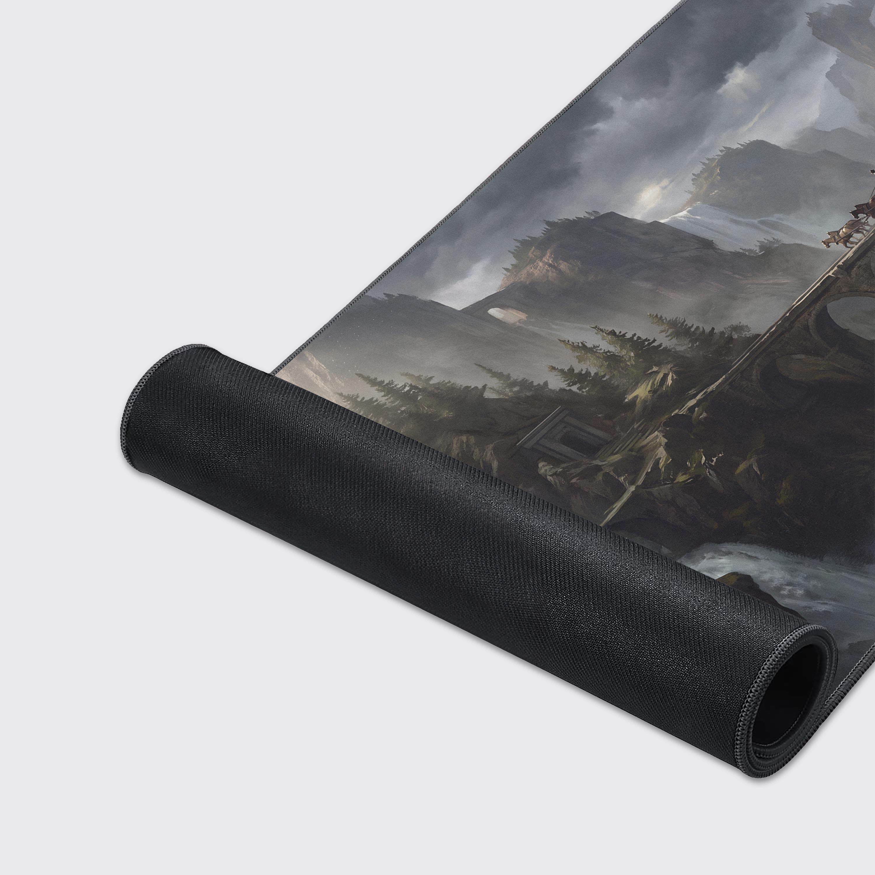Detailed view of the desk mat artwork featuring towering cliffs, pine trees, and cascading waterfalls in a moody gray atmosphere.