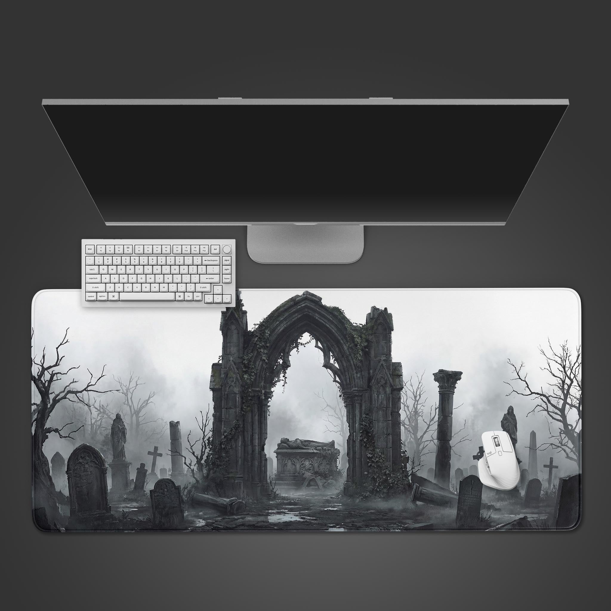A top-down view of the Stone Memory Gaming Desk Mat, featuring a gothic graveyard scene, with a white keyboard and mouse placed on it. - Epic Design Pads & Mousepads