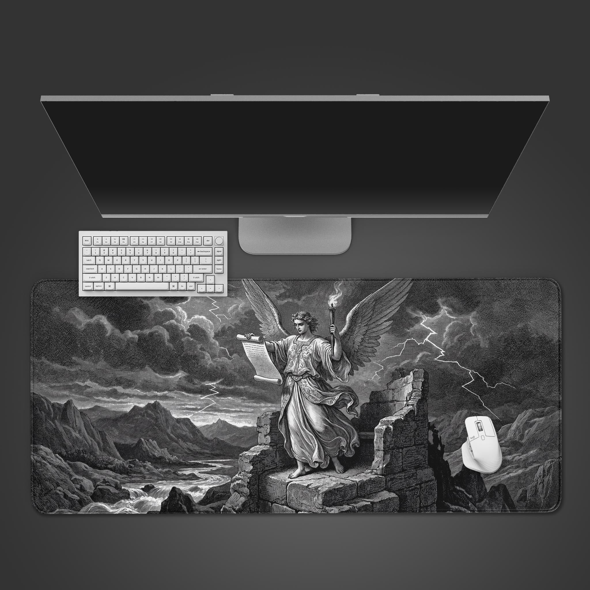A top-down view of the Storm Revelation gaming desk mat, featuring a vintage angel design. A white keyboard and mouse are shown on the mat below a monitor. - Epic Design Pads & Mousepads