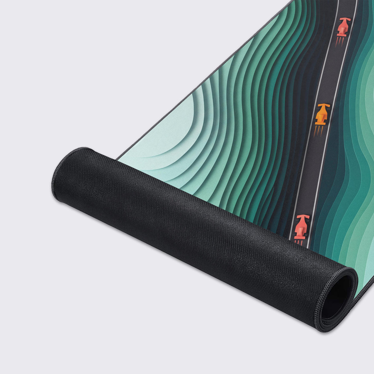 Partly rolled mat showing its black rubber underside, teal layered ridges and three race cars on a gray track
