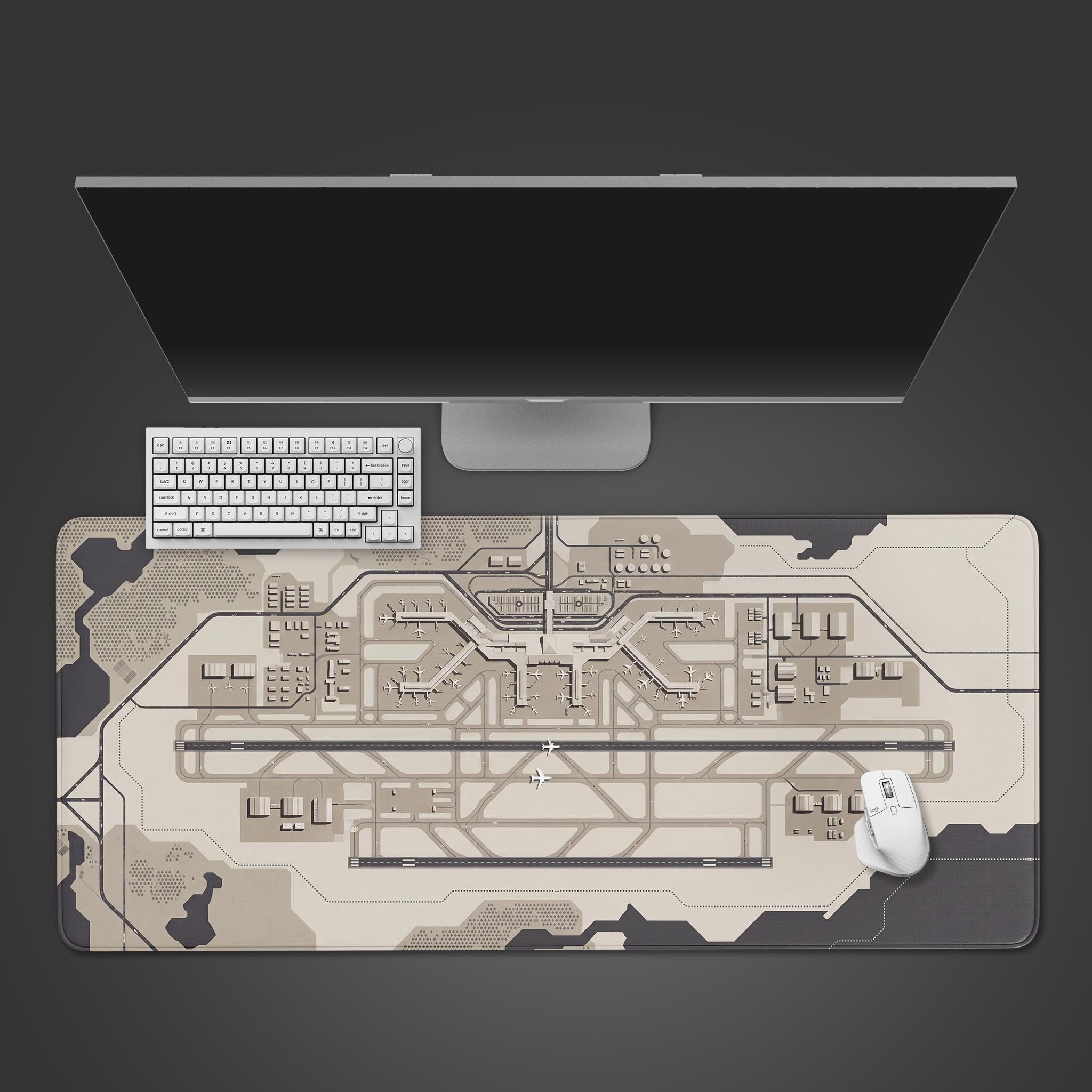 Top-down view of the Terminal Blueprint gaming desk mat, featuring an airport schematic. A white keyboard and mouse are placed on the mat below a large monitor. - Epic Design Pads & Mousepads