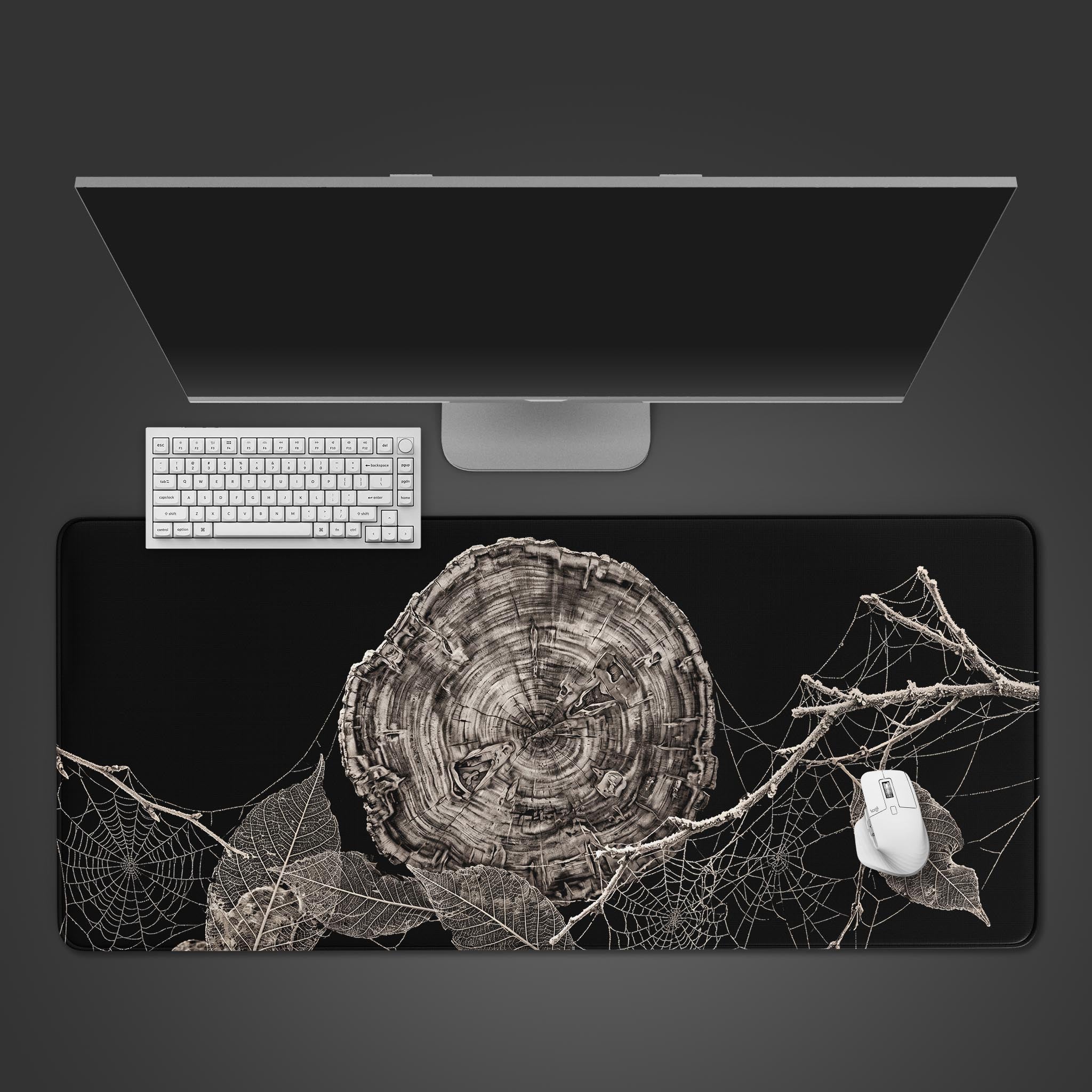 Large desk mat featuring high contrast black and white tree rings and spider webs