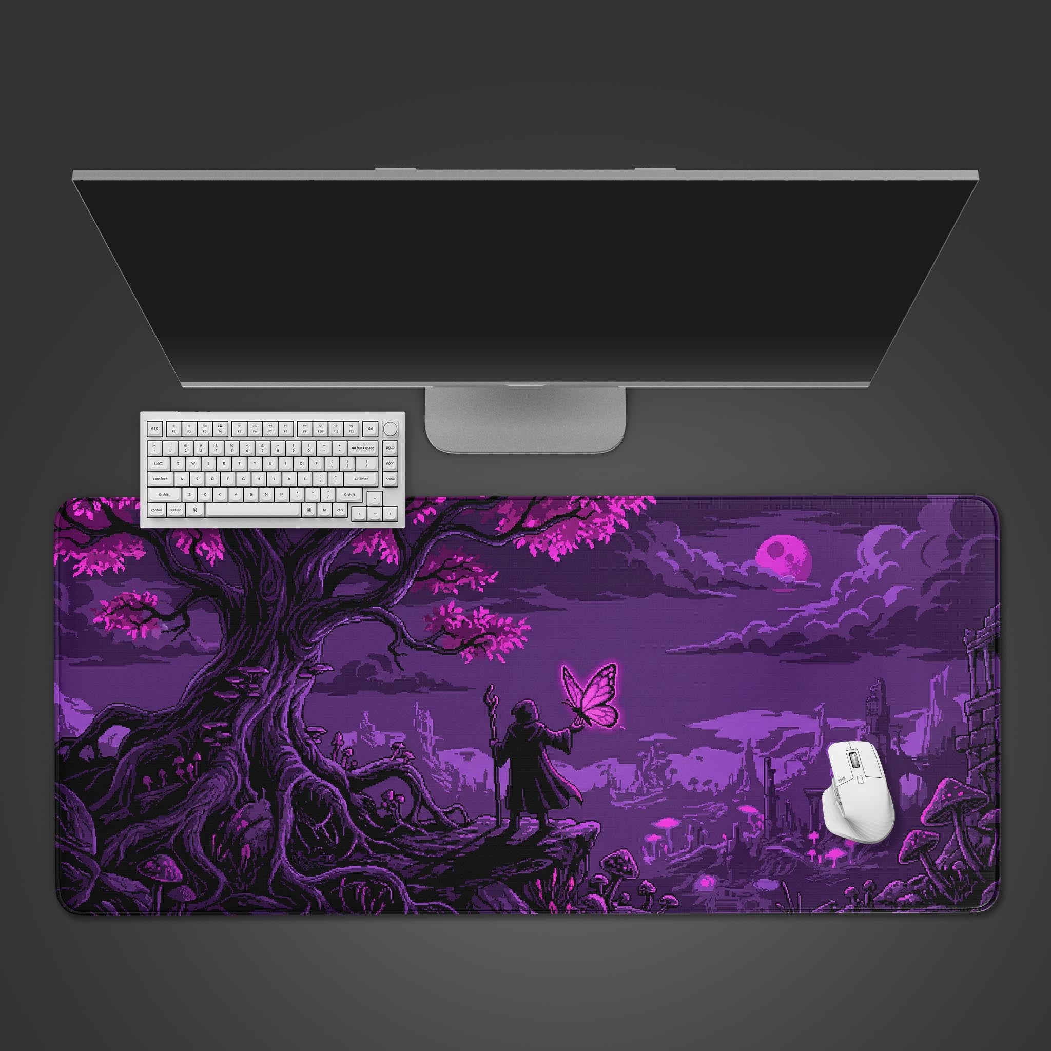 A top-down view of the Violet Realm gaming desk mat featuring a purple pixel art fantasy scene, shown with a white keyboard and monitor. - Epic Design Pads & Mousepads