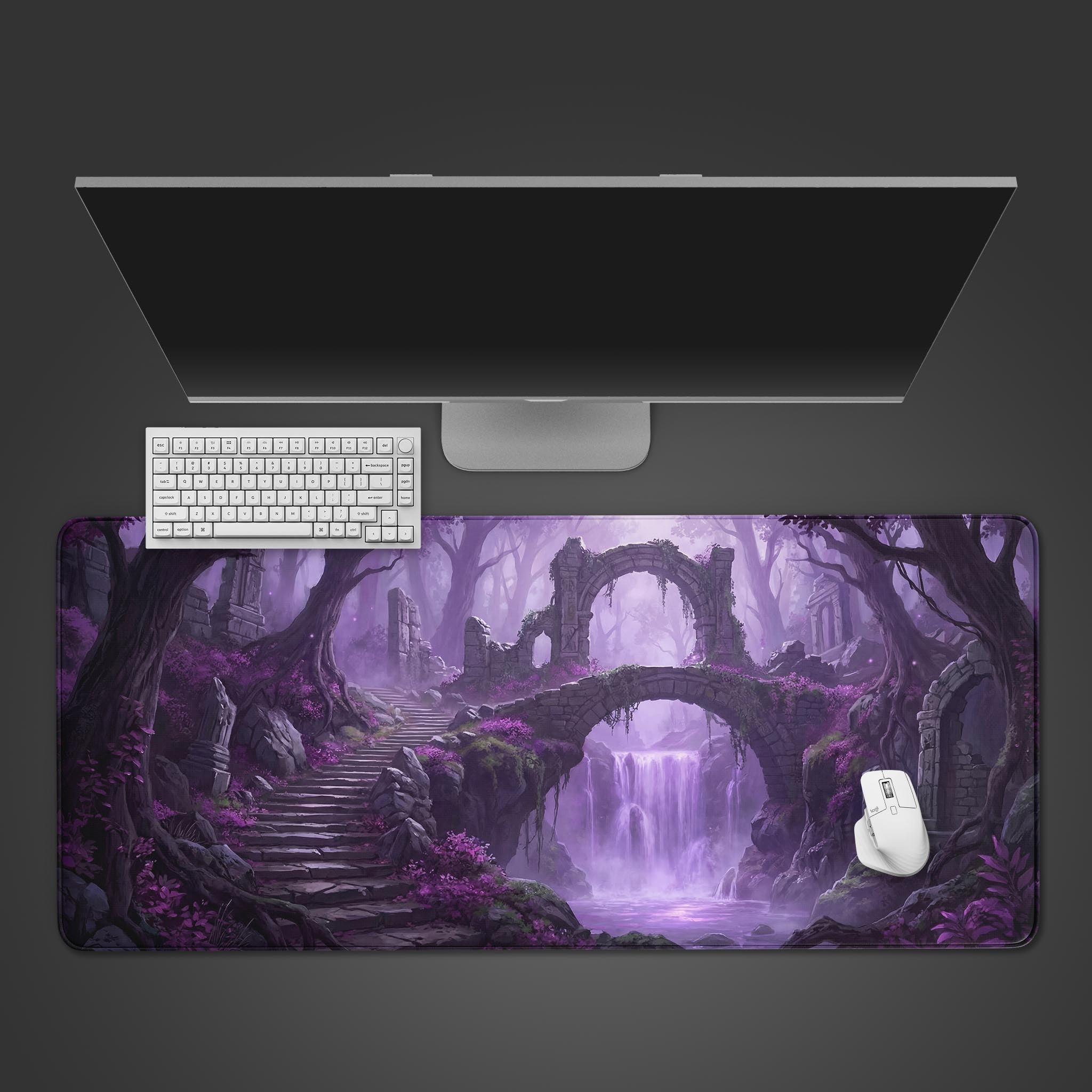 Top-down view of the Violet Ruins gaming desk mat, showing its purple fantasy landscape with ancient ruins and a waterfall, arranged with a white keyboard and mouse. - Epic Design Pads & Mousepads