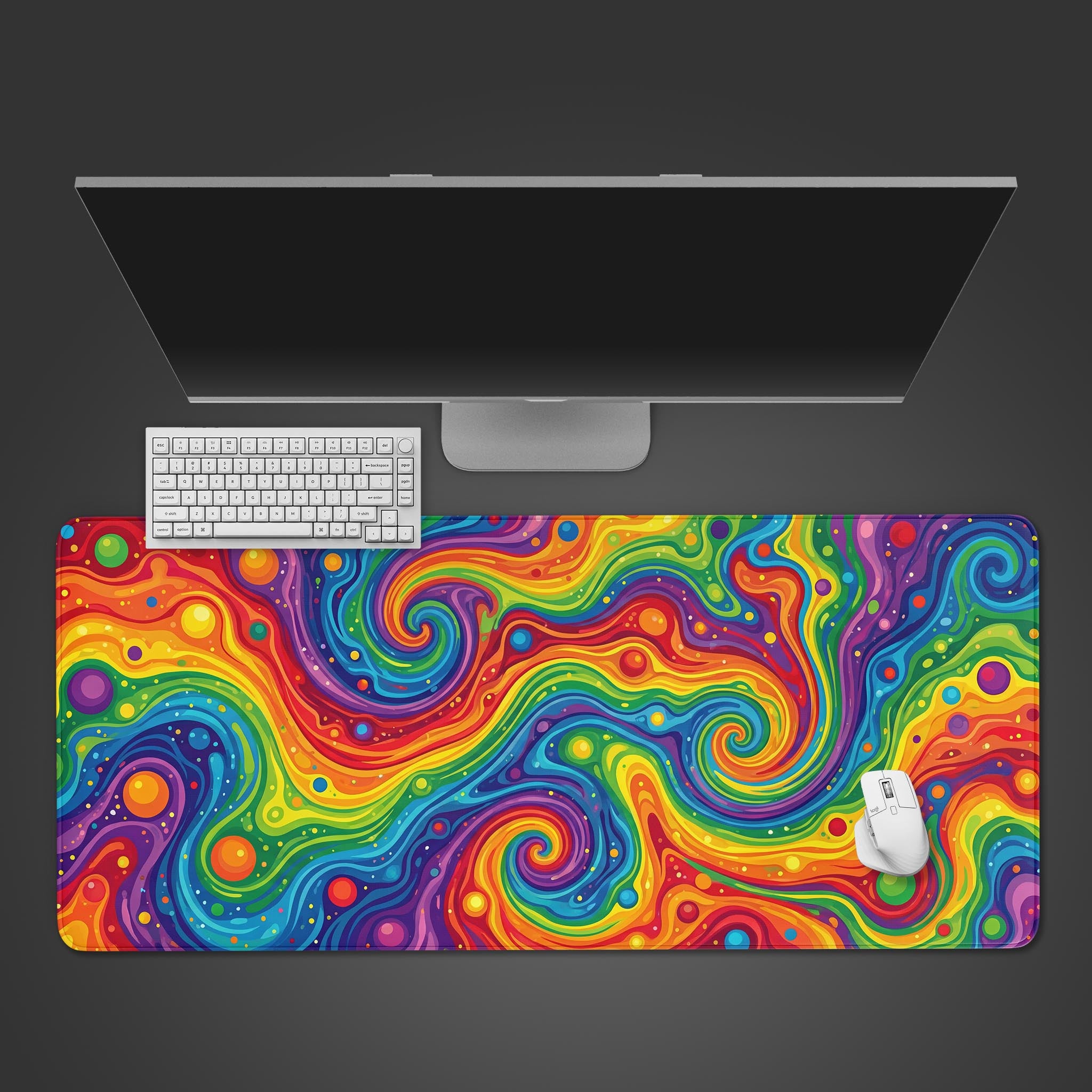 A top-down view of the Vivid Chaos gaming desk mat, its psychedelic rainbow pattern underneath a white keyboard and mouse, with a monitor at the top. - Epic Design Pads & Mousepads