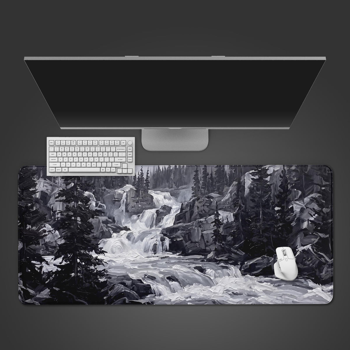 A wide desk mat displaying a monochromatic oil-painting style waterfall in a rugged forest.